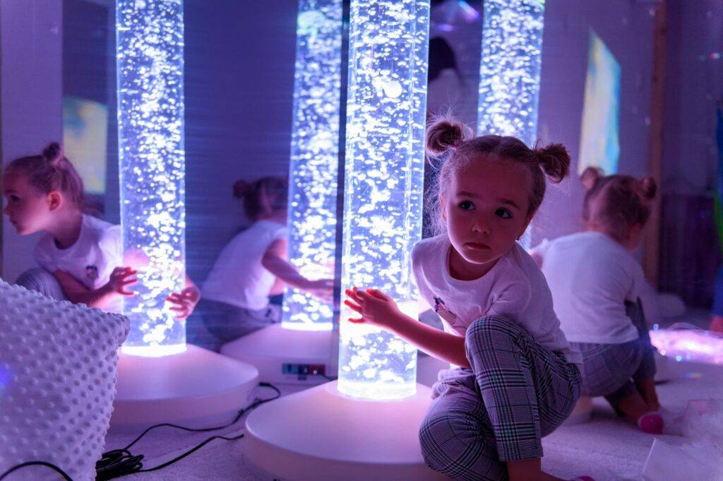 young girl touching bubble lamp