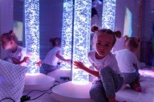 young girl touching bubble lamp
